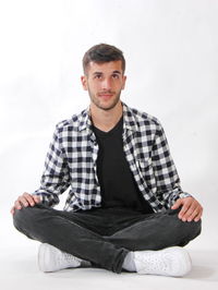 Thoughtful man sitting against white background