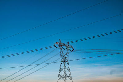 Low angle view of power cables against sky