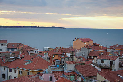 High angle view of townscape by sea against sky