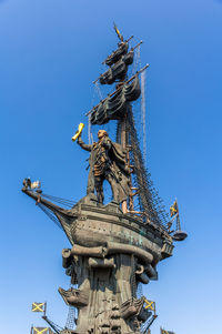 Low angle view of statue against blue sky