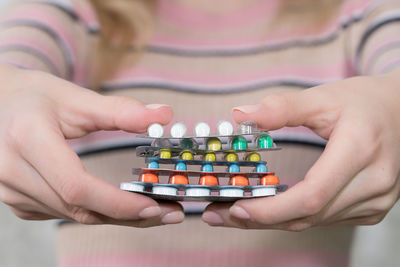 Cropped hands of woman holding pills