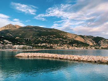 Scenic view of lake by mountains against sky