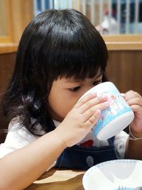 Portrait of a girl drinking water from table