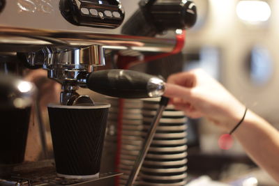 Cropped hand using espresso maker at home