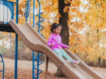 Girl sitting on swing in park