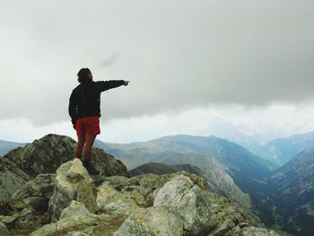 Man looking at mountains against sky