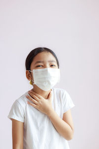 Portrait of boy wearing mask against white background