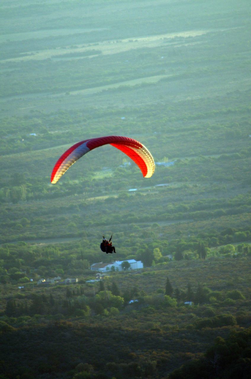 adventure, extreme sports, mid-air, parachute, leisure activity, paragliding, flying, sport, lifestyles, unrecognizable person, exhilaration, freedom, water, red, day, recreational pursuit, waterfront, tranquility