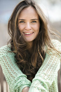 Portrait of smiling young woman with long brown hair