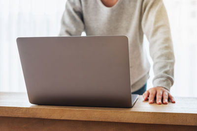 Midsection of man using laptop on table