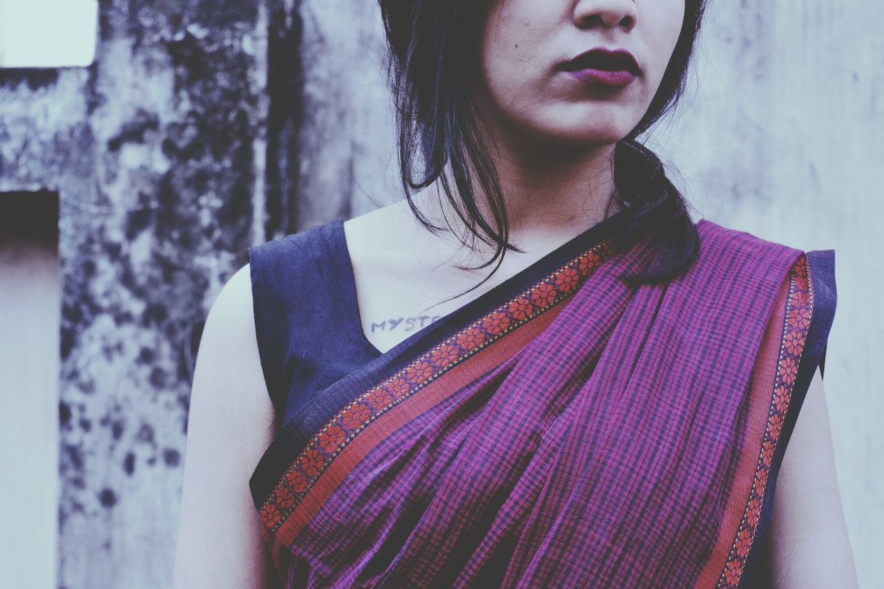 Midsection of young woman standing wearing sari