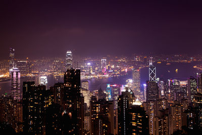 Illuminated cityscape against sky at night
