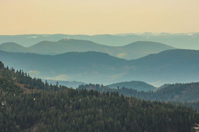 A mysterious landscape of mountains shrouded in fog and towering over the mummelsee in germany