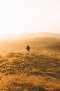 Silhouette man walking on mountain against clear sky