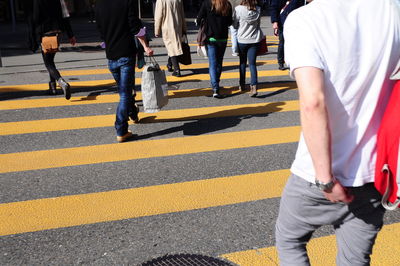 Low section of people walking on city street