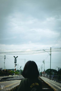 Rear view of woman on road against sky