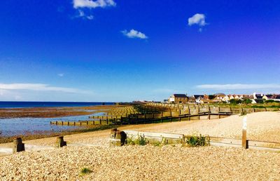 Scenic view of beach against blue sky