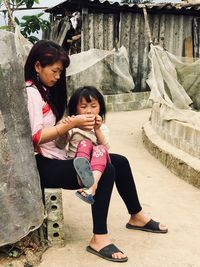 Full length of mother and woman sitting outdoors