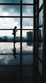 Side view of silhouette man against glass window