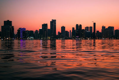 Modern buildings in city against clear sky during sunset