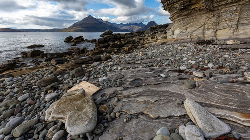 Scenic view of rocky shore and sea against sky