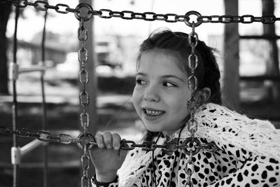 Close-up of smiling girl seen through fence