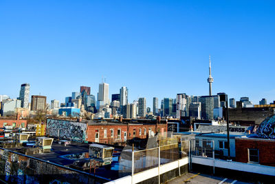 Modern buildings in city against clear blue sky