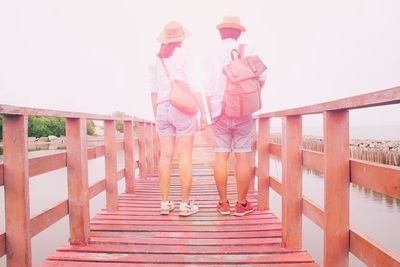 Rear view of couple standing on footbridge