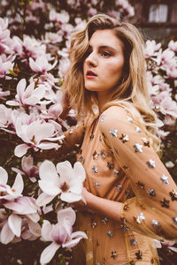 Woman standing by flowering plants