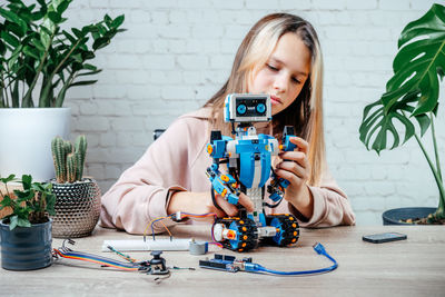 A girl building and programming robot while studying robotics engineering and coding