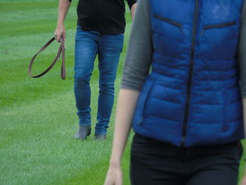 Low section of man and woman walking on grass