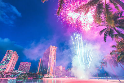 Low angle view of firework display at night