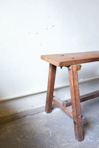 Close-up of wooden table against wall at home