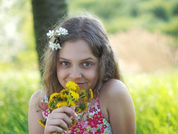 Portrait of woman holding flower against blurred background