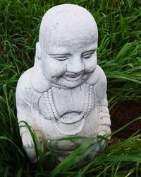 Close-up of buddha statue on field