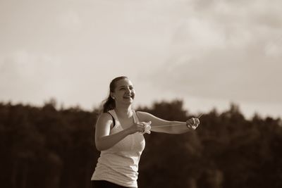 Smiling young woman holding thread