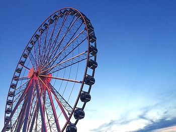 Low angle view of ferris wheel against blue sky