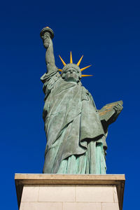 Low angle view of statue against blue sky