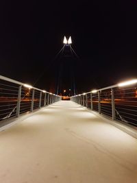 Illuminated bridge against sky at night