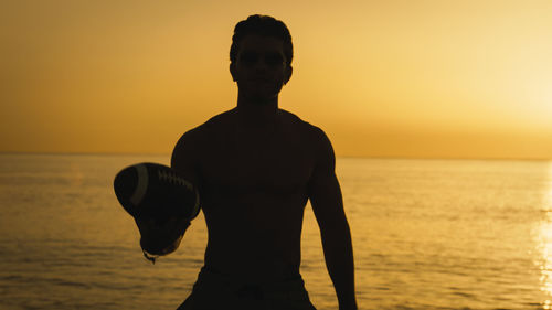 Silhouette of a football player with ball