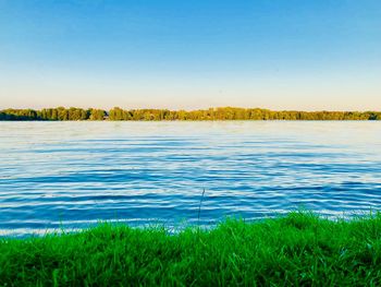 Scenic view of lake against clear blue sky