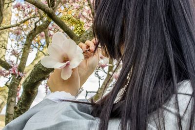 Close-up of young woman admiring a flower