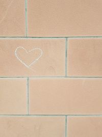 Close-up of heart shape on brick wall