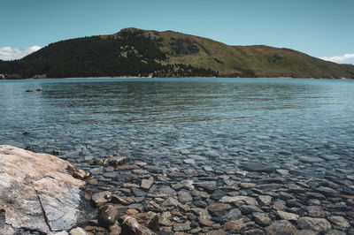 Scenic view of sea and mountains against sky