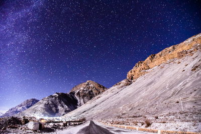 Scenic view of snowcapped mountains against sky at night