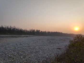 Scenic view of snow covered land against sky during sunset