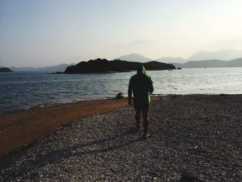 Rear view of woman standing on shore