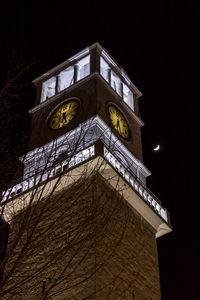 Low angle view of clock tower against sky at night