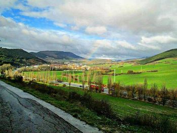 Scenic view of field against cloudy sky