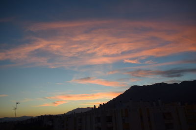 Silhouette city against sky during sunset